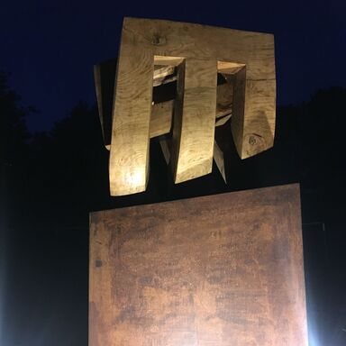 Die Skulptur Niemandsblau bei Nacht, hell angestrahlt vor dunklem Nachthimmel