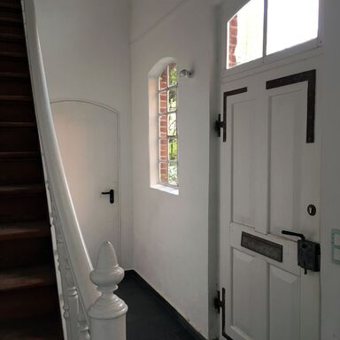 Der Eingang zum Loft ist eine alte Tür mit schweren Metallbeschlägen, links führt eine Treppe zum Loft hinauf