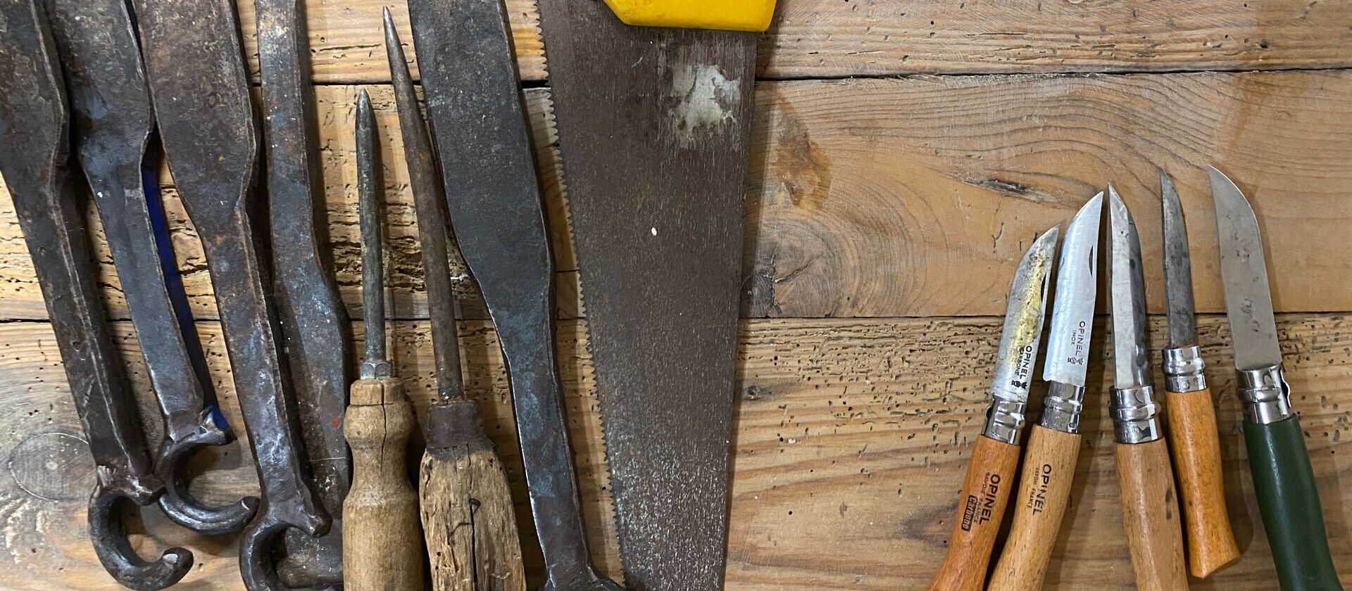 verschiedene Werkzeuge zum Korbflechten auf Holzdielen