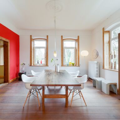 Mikaelas Studio Lichtdurchflutetes Studio von Mikaela Dörfel mit Holzdielen, großen Holzregalen an den Wänden und einem großen Tisch mit Stühlen in der Mitte. In den Regalen steht Porzellangeschirr.